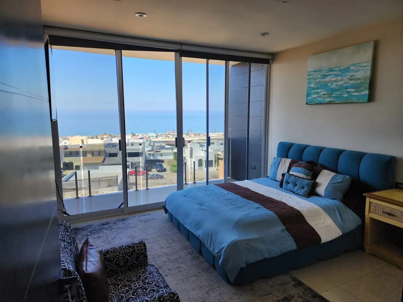 A patient bedroom at Rite of Passage Mexico in Rosarito, with sliding glass doors opening onto a Pacific Ocean view